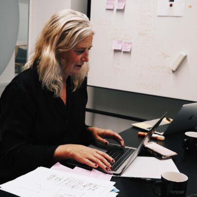 En kvinna sitter och gör research på en dator.