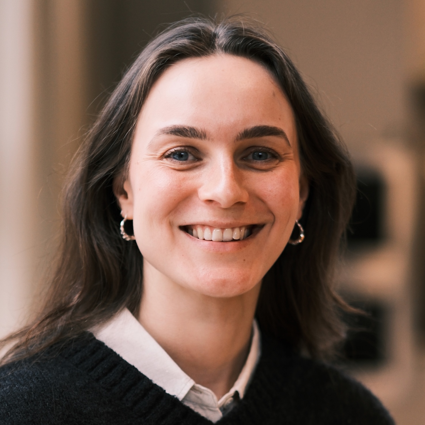 En bild på Maja Jakobsson i brunt hår som ler