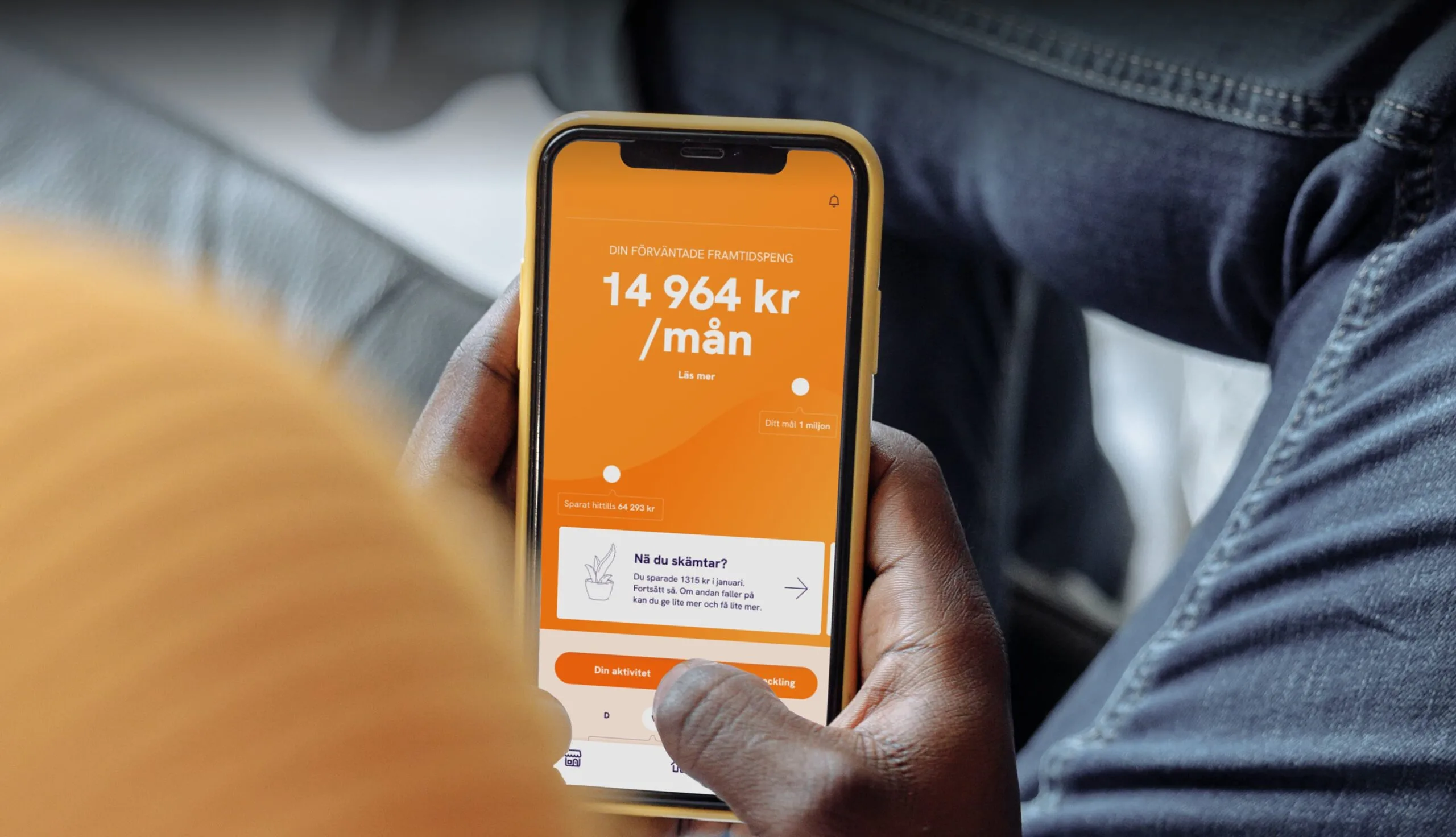 En person håller i en mobil med Nowo-appen öppen
